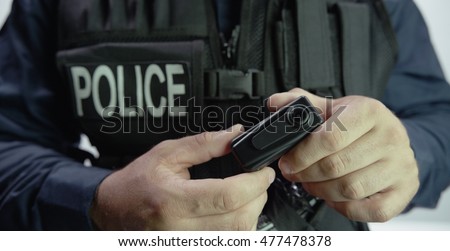 Police officer holding Law Enforcement body camera video recorder