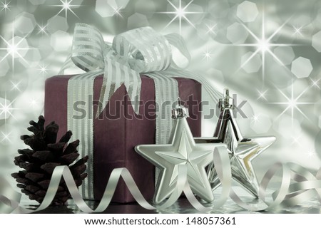 Wrapped present with silver ribbon,stars,and a pine cone