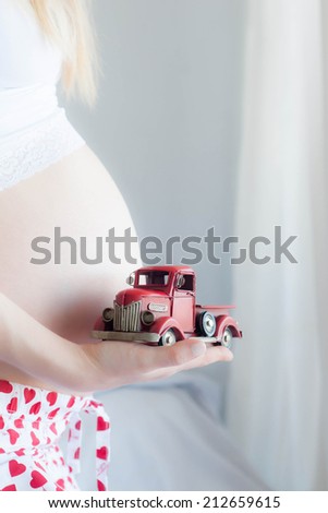 Pregnant Woman plays with a tinny little toy car