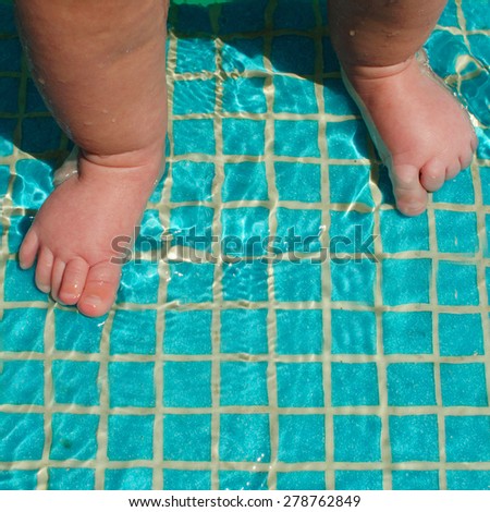 Baby\'s feet in swimming pool