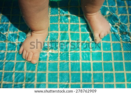 Baby\'s feet in swimming pool