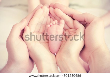 hands of parents concerned barefoot baby
