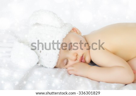 Funny sleeping newborn child. Bunny cap on head of girl.