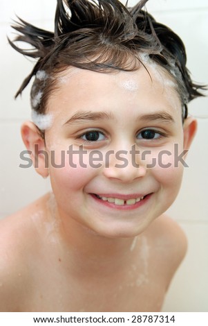 Young boy (7-8) having fun under the shower