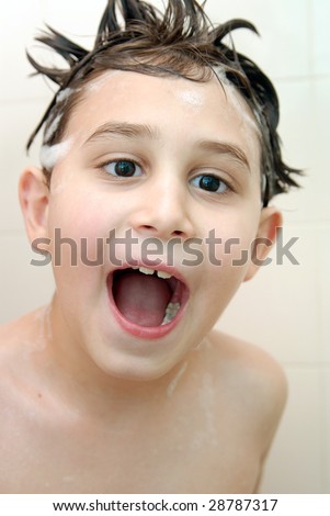 Young boy (7-8) having fun under the shower