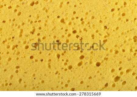 Yellow washing sponge with holes and bubbles used for cleaning background