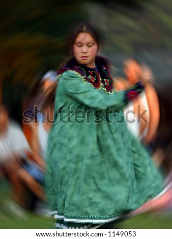 Young american indian dances for the crowd, motion blur applied to give the feeling of motion