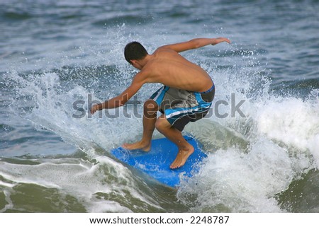 young man on the beach testing his balance in the water