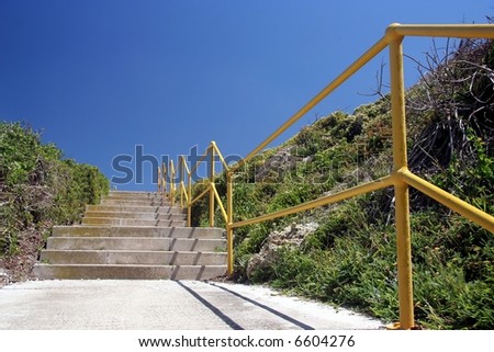 Concrete steps and yellow handrail with blue sky