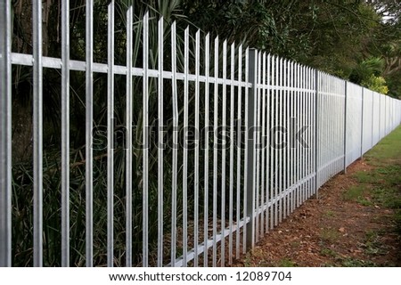 Galvanized steel palisade fence on the border of a property