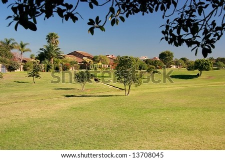 Open ground between houses in a suburb for drainage and recreation