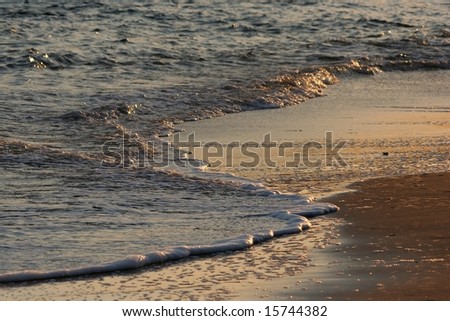 Sea water lapping the sand at the ocean\'s edge
