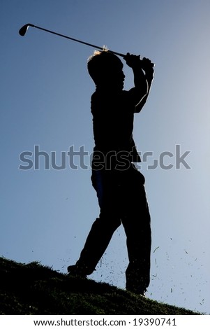 Silhouette of a golf player on the fairway