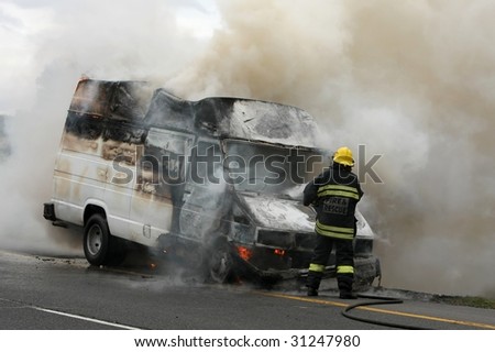 Fireman putting out burning van on the side of the road