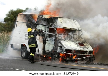 Fireman extinguishing a fire in a burning delivery van