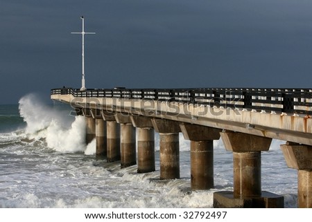 Stormy seas breaking against a concrete pier at the seaside