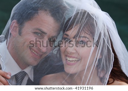 Husband and wife on wedding day under the veil