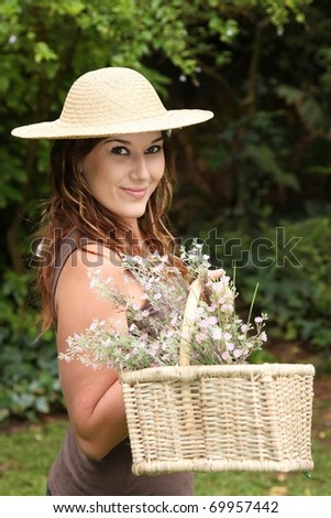 Pretty gardening woman with a basket of flowers