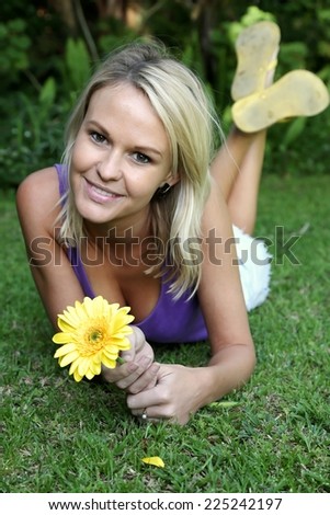 Pretty young lady playing he loves me he loves me not with yellow daisy flower