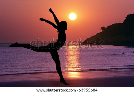 Girl jumping on the beach at sunset.