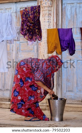 Indian woman in sari hanging linen