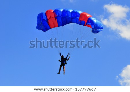 Blue and red sail parachute on blue sky