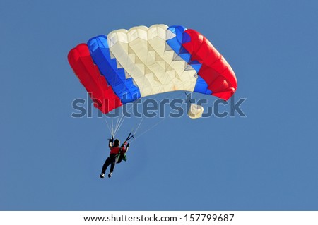 Blue white and red sail parachute on blue sky