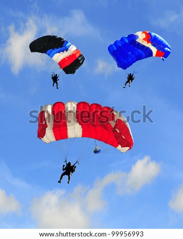 Three parachutes on blue sky.