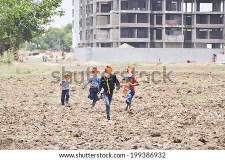 GANDHINAGAR, GUJARAT/INDIA - MAY 16TH 2014: Boys running in field after winning election on 16 May in BJP office Gandhinagar, India.