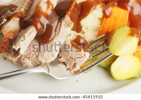 Closeup of a fork with meat and vegetables