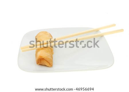 Chinese pancake roll and chopsticks on a white plate