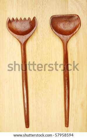 Wooden salad serving spoons on a wood background