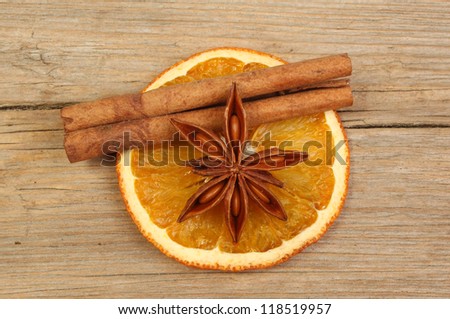 Slice of dried orange with star anise and cinnamon on old weathered wood