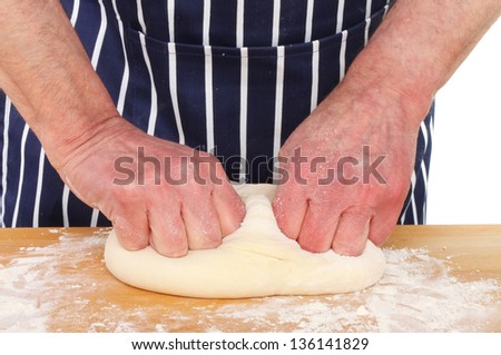 Pair of male hands kneading bread dough on a kitchen worktop