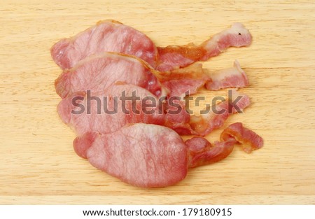 Cooked bacon rashers on a wooden board