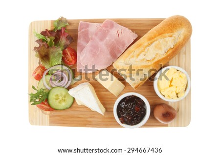 Ham and cheese ploughman\'s lunch on a wooden platter viewed from above on a wooden platter