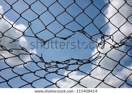 Opening in metallic fence against a blue sky with white clouds. Challenge / uncertainty / breakthrough concept / metaphor.\
\
Happy - sad,