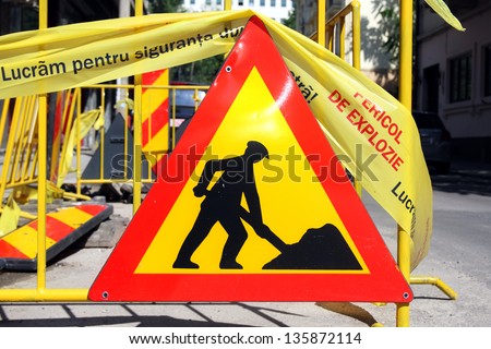 \'Men at work\' road sign. The text on the yellow tape reads \