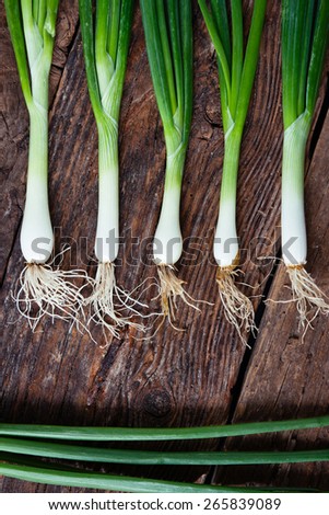 Spring onions on a rustic wooden board.