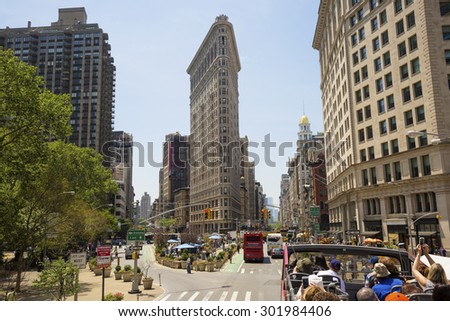 NEW YORK, USA - MAY 27, 2015: Flat Iron building facade with tourists in bus. New York, USA on May 27, 2015. Completed in 1902, it is considered to be one of the first skyscrapers ever built.