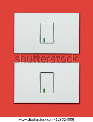 Electrical white rocker light switch on red wall.