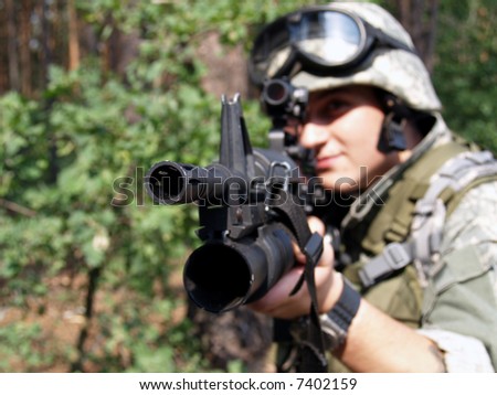 Soldier in ACU aiming his Colt M4 with M203 grenade launcher