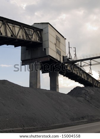 The coal mine, plies of coal and the cloudy sky