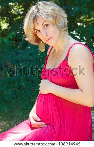 Pregnant woman sitting outside in the park