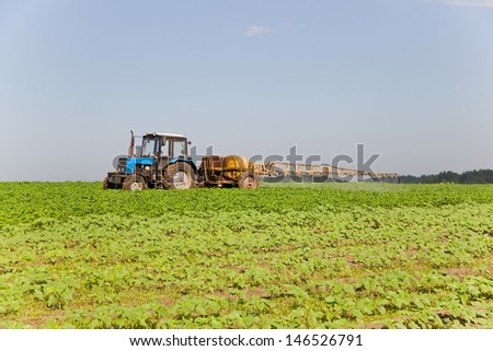 Tractor spraying the soy field on a sunny day