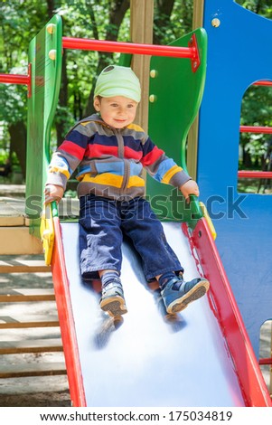 Baby having fun on the slide in the park