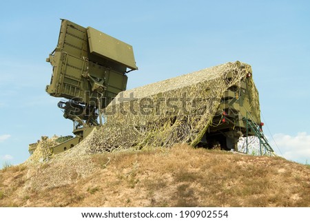 Mobile tactical air defense radar on position covered with a camouflage net