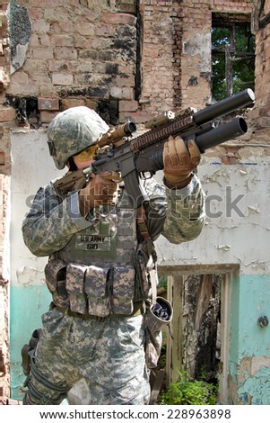 US Soldier on urban patrol mission aiming his rifle