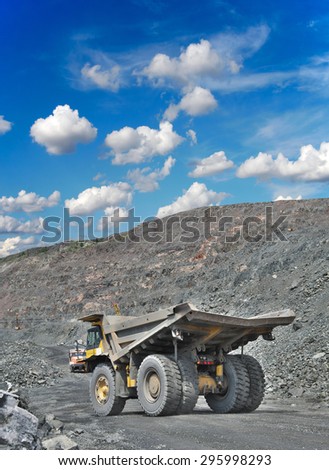Heavy dump truck on the iron ore opencast on a sunny day