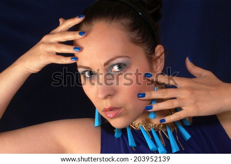 Portrait about a woman with blue jewelry and make up.